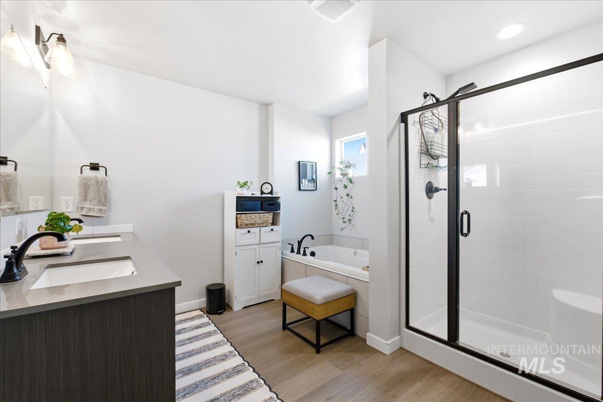 5392 South Memory Way Meridian, ID 83642 - Photo 23 of 39 Bathroom featuring double vanity, a bath, light wood finished floors, and a shower stall