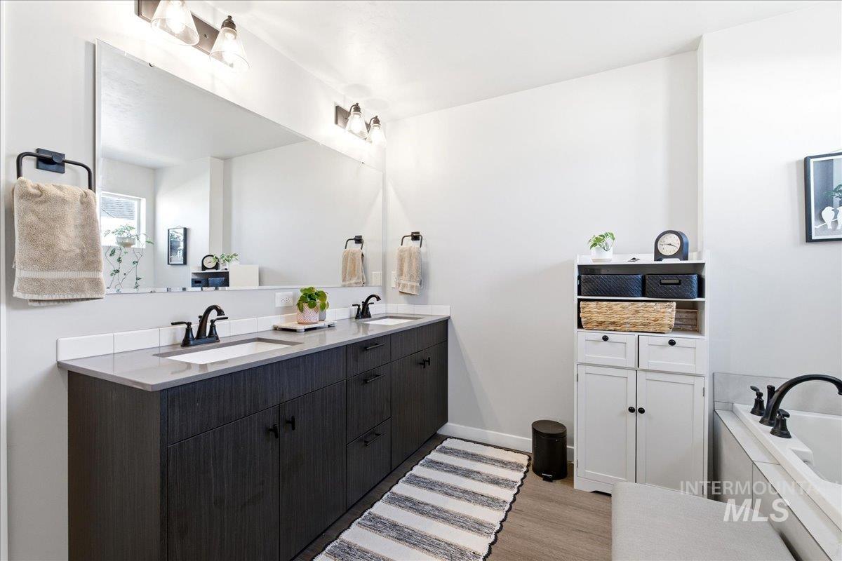 5392 South Memory Way Meridian, ID 83642 - Photo 24 of 39 Bathroom featuring double vanity, a bath, and light wood-style flooring