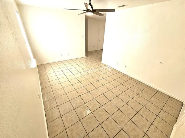 a view of a storage & utility room with fridge and wooden floor