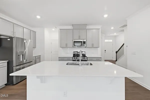 a kitchen with stainless steel appliances a refrigerator sink and microwave