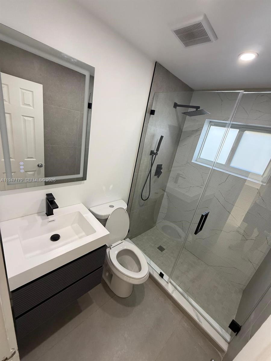 6891 Scott Street Hollywood, FL 33024 - Photo 13 of 28 a bathroom with a toilet sink and mirror