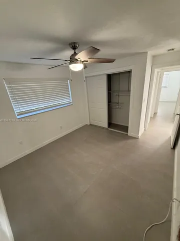 en empty room with windows and ceiling fan
