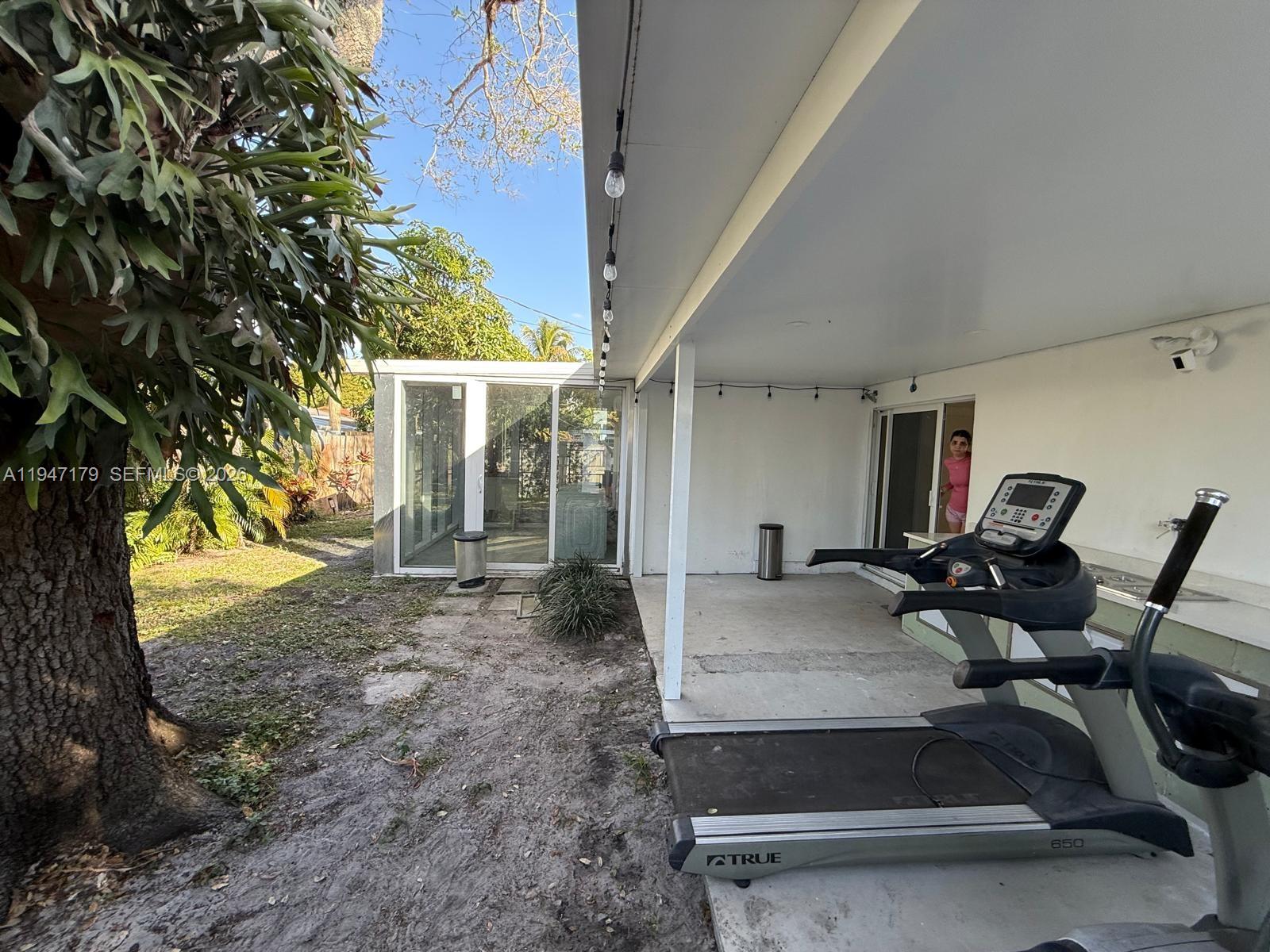 6891 Scott Street Hollywood, FL 33024 - Photo 24 of 28 a view of a patio with table and chairs near a large tree