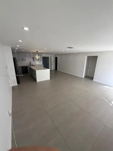 an empty room with a kitchen and a sink