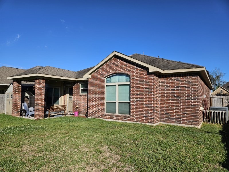 5710 Micah Lane Rosenberg, TX 77471 - Photo 1 of 36 Rear exterior of brick home with large windows and lawn.