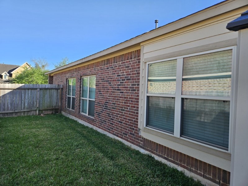 5710 Micah Lane Rosenberg, TX 77471 - Photo 32 of 36 Side view of home exterior with windows and fenced yard.