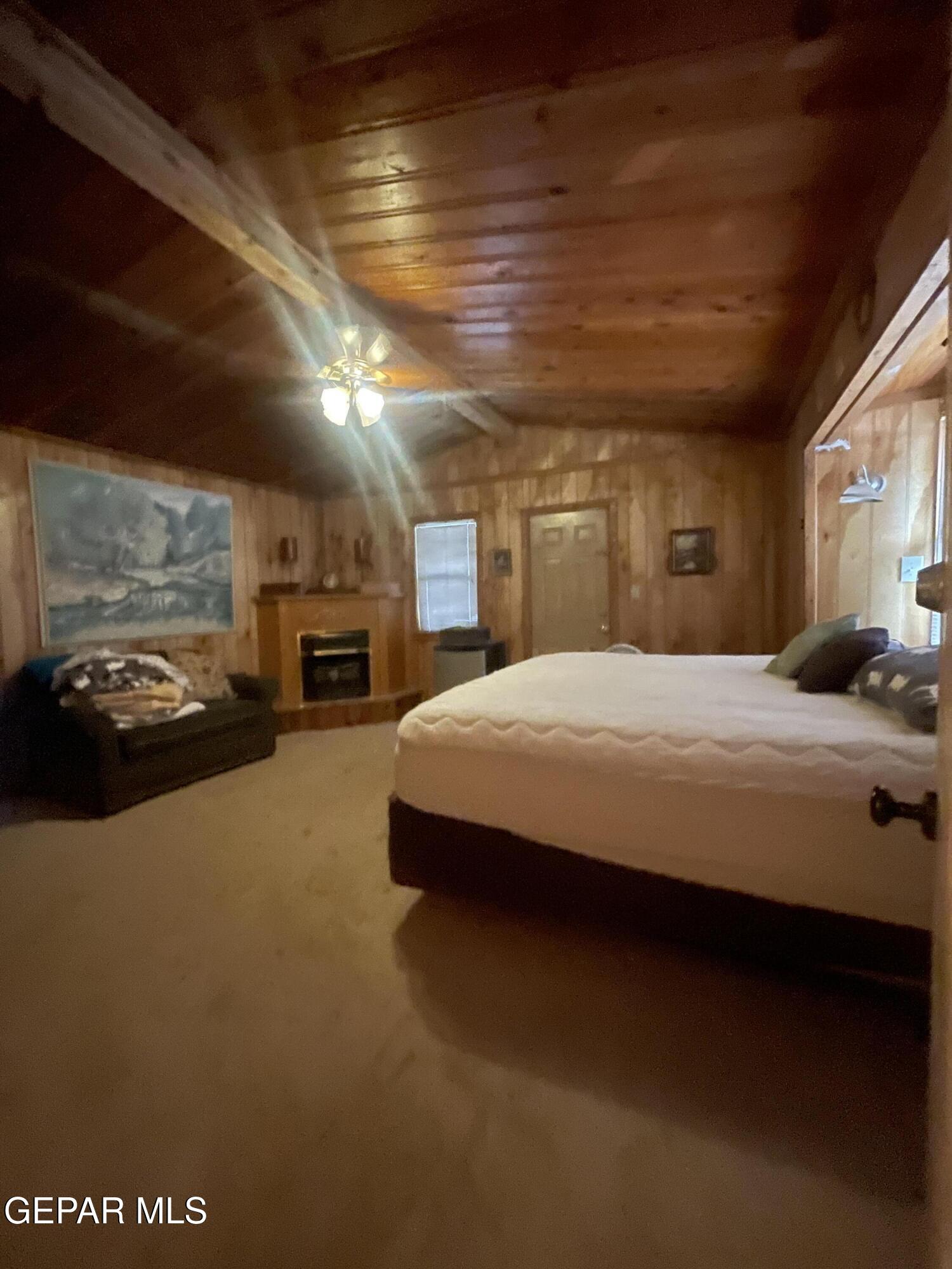 217 Juniper Road Ruidoso, NM 88345 - Photo 4 of 7 a large bed sitting in a room next to a lamp