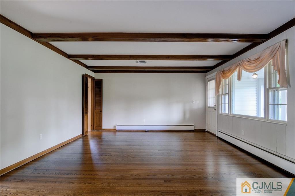 87 West Hill Road Colonia, NJ 07067 - Photo 11 of 18 a view of an empty room with wooden floor and a window