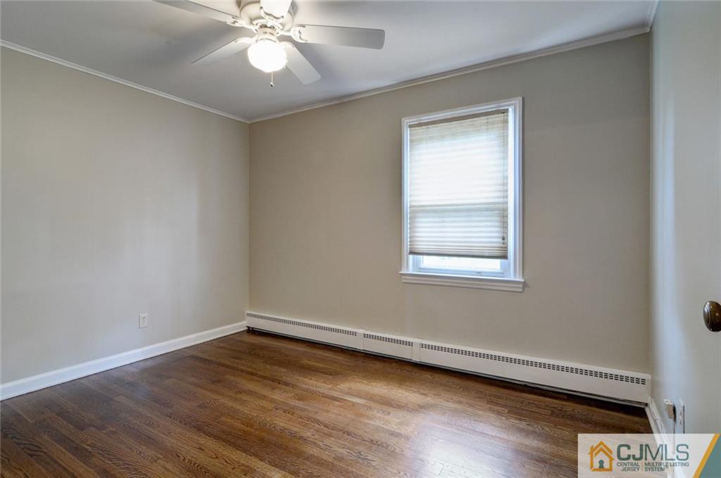87 West Hill Road Colonia, NJ 07067 - Photo 13 of 18 a view of wooden floor and chandelier fan in a room