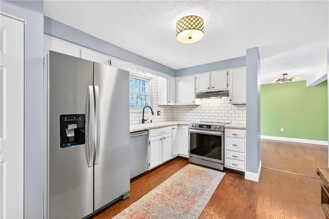 a kitchen with a refrigerator and a stove top oven