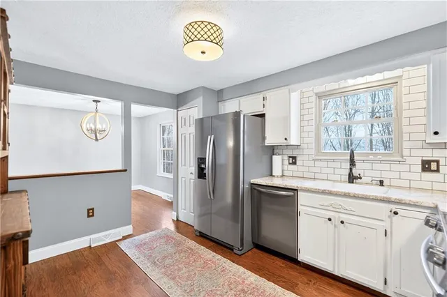 a kitchen with stainless steel appliances granite countertop a sink a stove a refrigerator and island