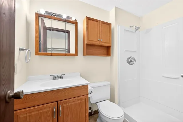a bathroom with a toilet sink vanity and mirror