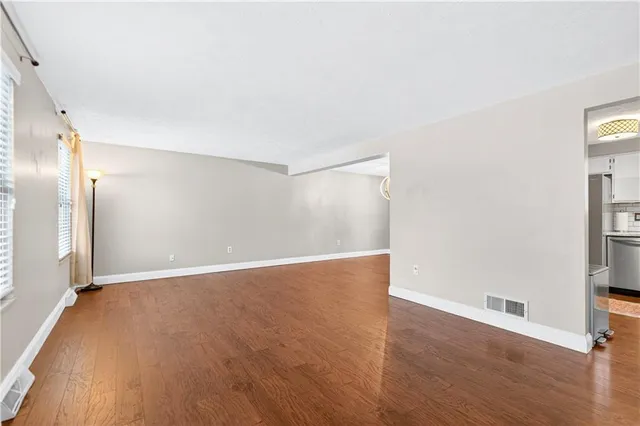 a view of an empty room with wooden floor
