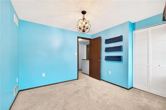 a view of an empty room with window and cabinet
