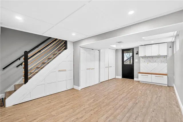 a view of an empty room with wooden floor and staircase