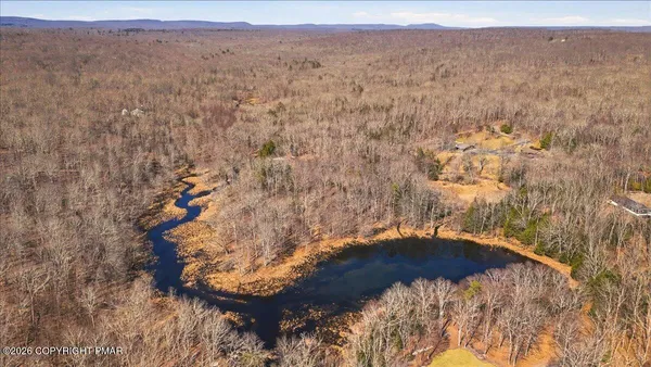 an aerial view of house with yard and mountain view in back