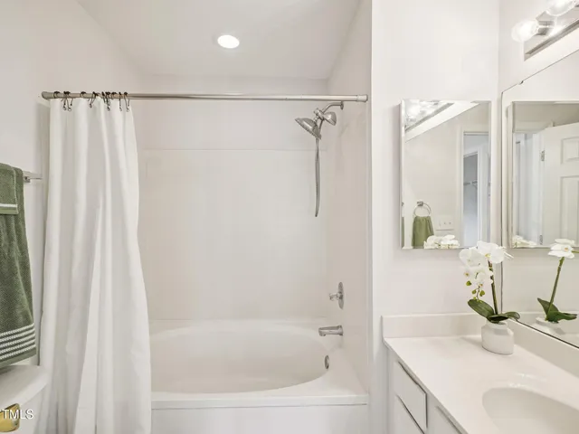 a bathroom with a granite countertop sink and a bathtub