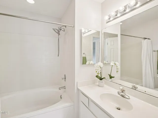 a bathroom with a bathtub shower sink vanity and a mirror