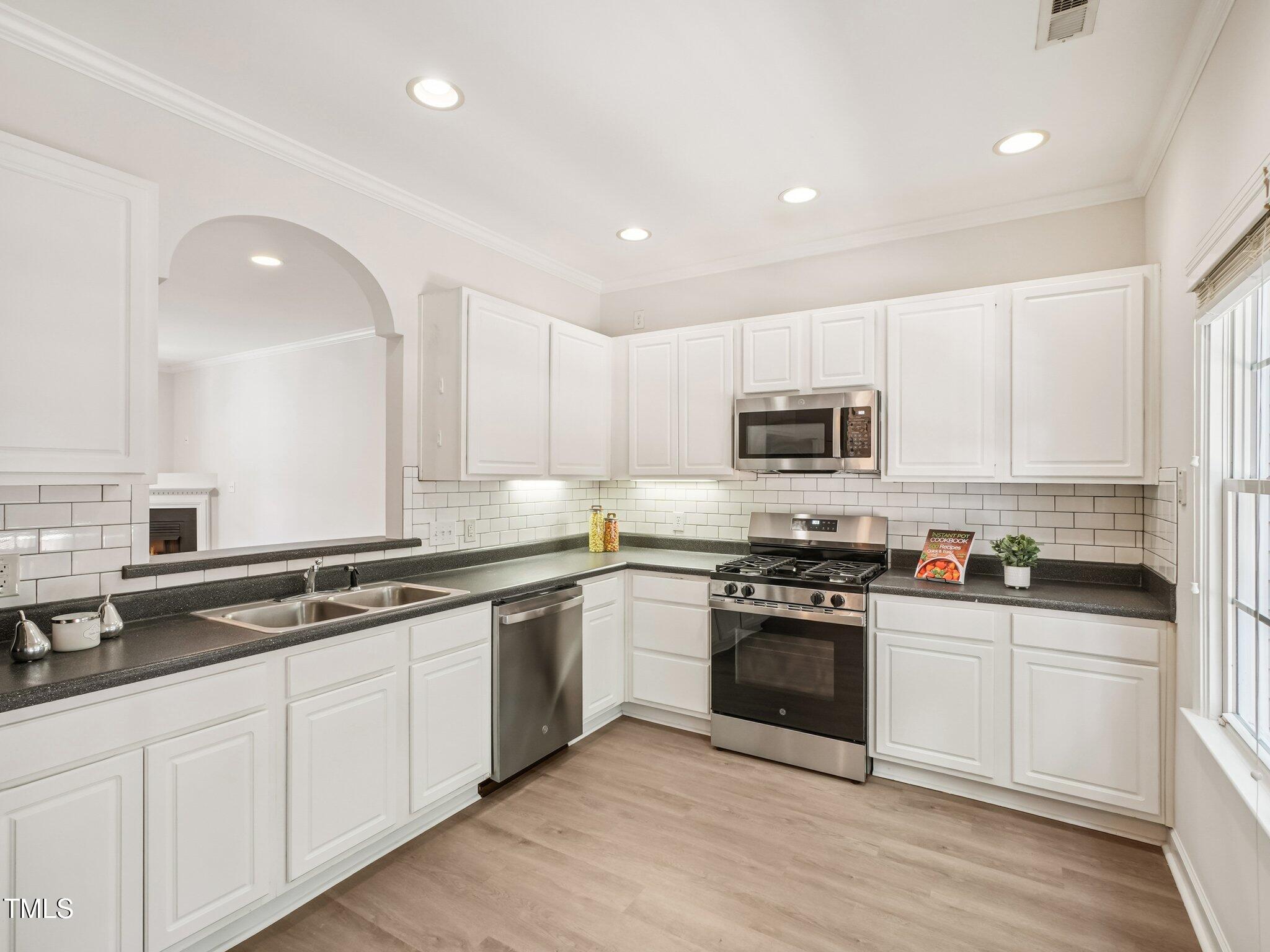 2228 Trailwood Valley Circle Raleigh, NC 27603 - Photo 6 of 19 a kitchen with granite countertop white cabinets and stainless steel appliances