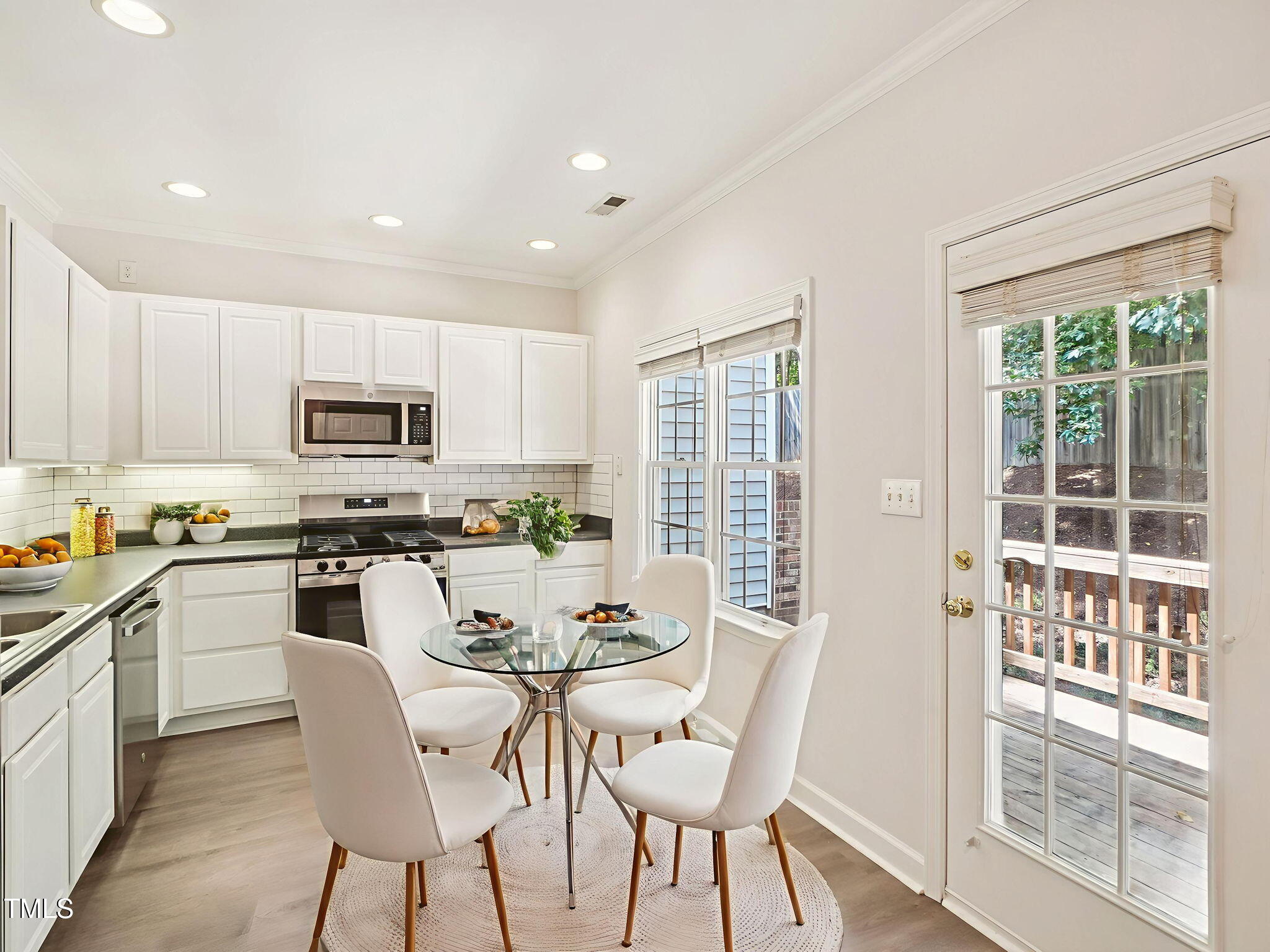 2228 Trailwood Valley Circle Raleigh, NC 27603 - Photo 7 of 19 a kitchen with stainless steel appliances granite countertop a stove top oven a sink dishwasher a dining table and chairs with wooden floor