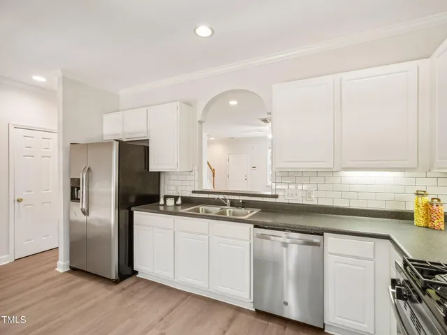 a kitchen with stainless steel appliances granite countertop a sink and a refrigerator