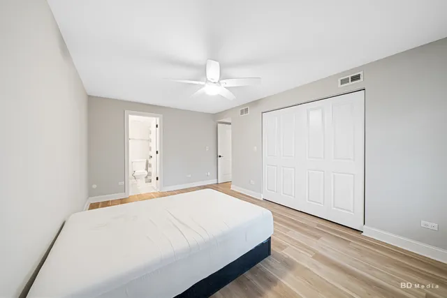 a spacious bedroom with a bed and a ceiling fan