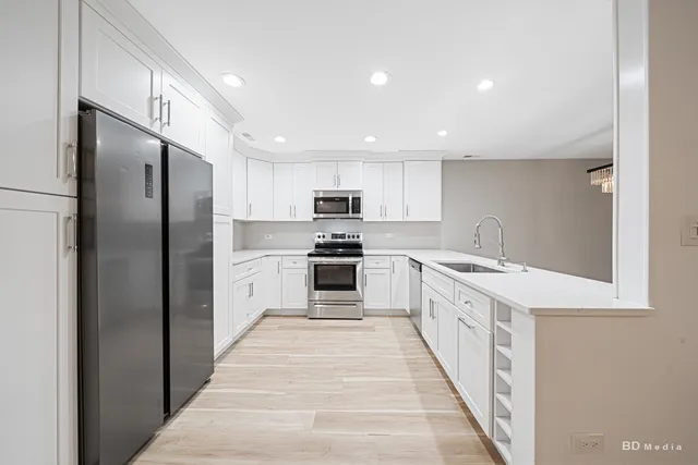 a large kitchen with stainless steel appliances kitchen island granite countertop a refrigerator and a stove top oven