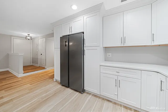 a kitchen with stainless steel appliances white cabinets and a refrigerator