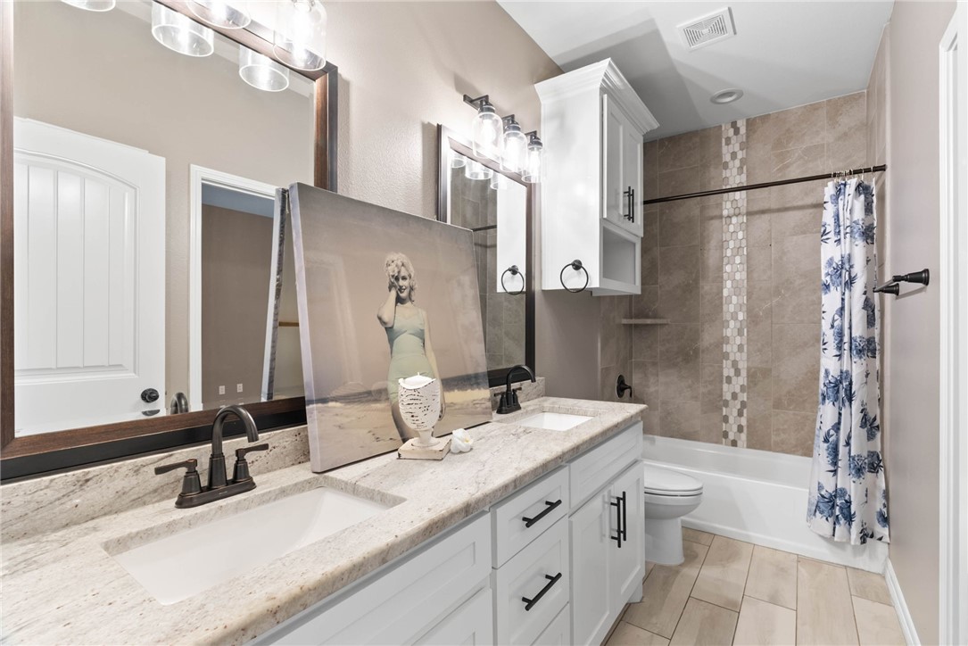 401 Big Shell Court Corpus Christi, TX 78418 - Photo 18 of 26 a bathroom with a double vanity sink mirror double and shower