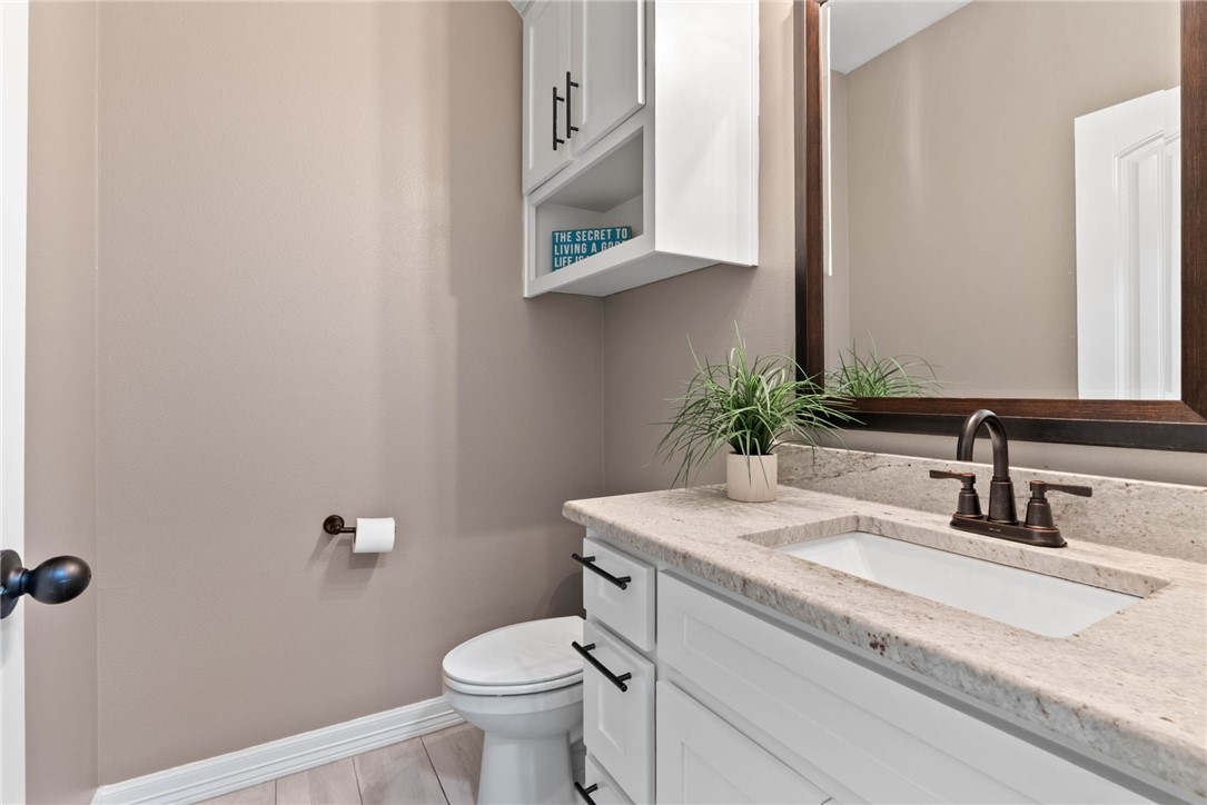 401 Big Shell Court Corpus Christi, TX 78418 - Photo 24 of 26 a bathroom with a granite countertop toilet sink and mirror