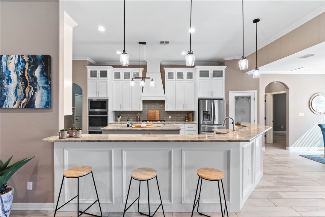 401 Big Shell Court Corpus Christi, TX 78418 - Photo 5 of 26 a kitchen with stainless steel appliances granite countertop a sink and a refrigerator