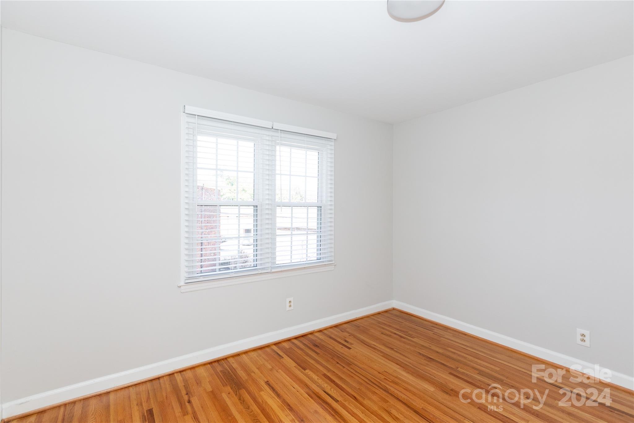 856 McAlway Road, Unit B Charlotte, NC 28211 - Photo 18 of 25 an empty room with wooden floor and windows