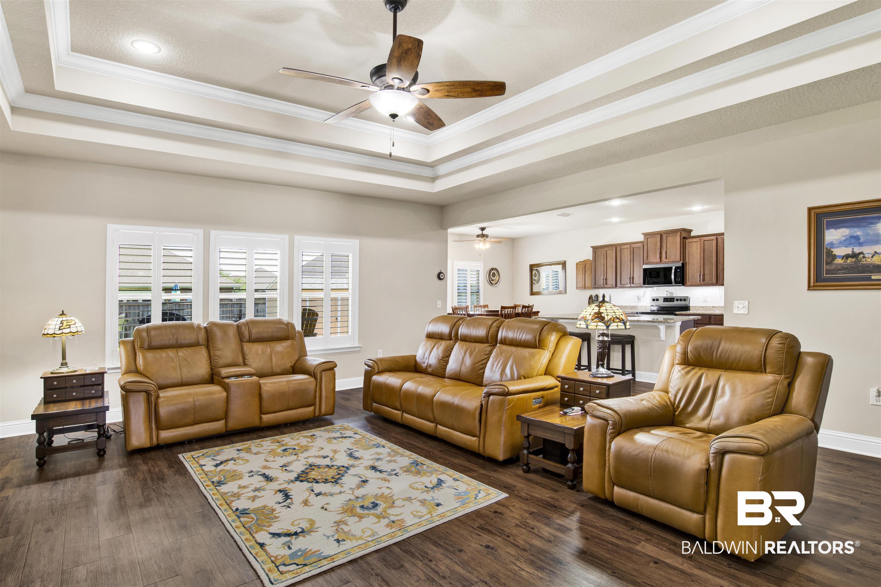278 Silo Loop Fairhope, AL 36532 - Photo 4 of 26 Living area featuring a ceiling fan, a tray ceiling, ornamental molding, dark wood-type flooring, and recessed lighting