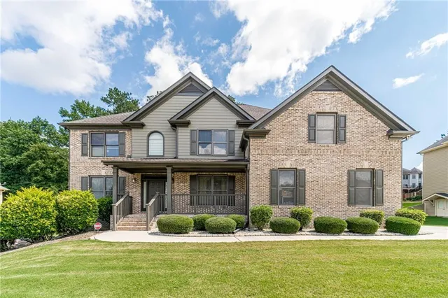 a front view of a house with garden and porch