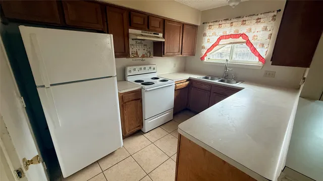 a kitchen with stainless steel appliances granite countertop a refrigerator a sink a stove and a microwave