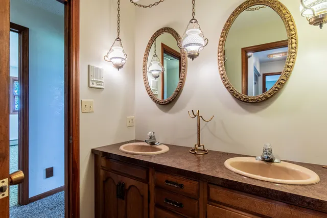 a bathroom with a granite countertop double vanity sinks and a mirror
