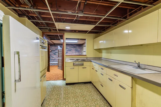 a view of a kitchen with a sink and wooden cabinets