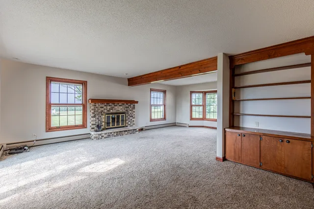 an empty room with a fireplace and window