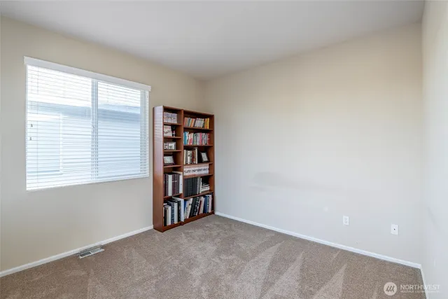 an empty room with bookshelf and a window