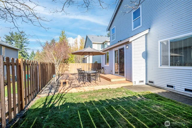 a view of a patio with table and chairs and wooden fence