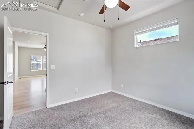 en empty room with ceiling fan and window