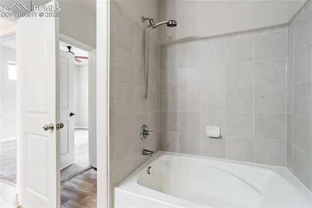 a white bath tub sitting next to a shower