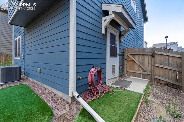 a view of backyard with wooden fence and a bench