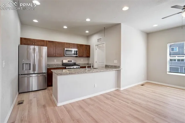 a kitchen with stainless steel appliances granite countertop a refrigerator microwave and stove