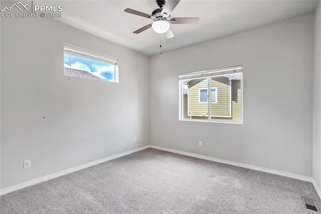 an empty room with a window and a fan