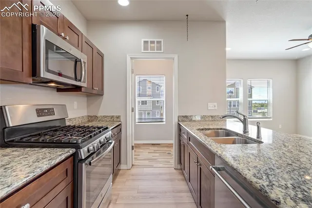 a kitchen with stainless steel appliances granite countertop a sink stove and cabinets