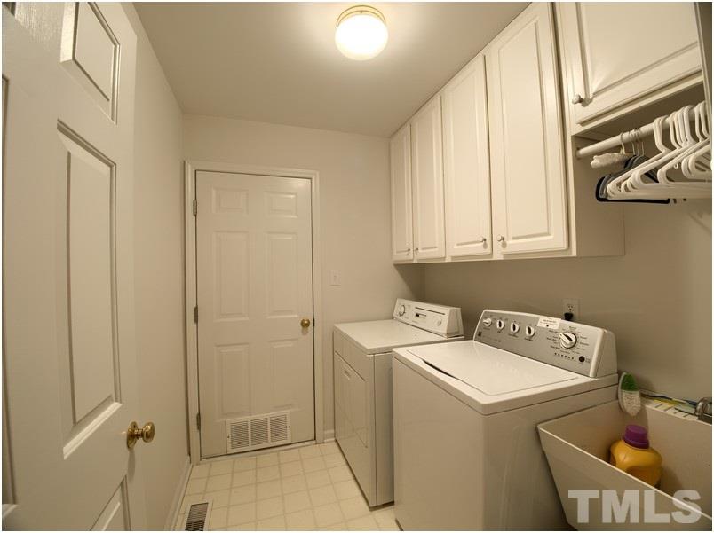 8501 Bluebill Court Raleigh, NC 27615 - Photo 24 of 25 Large laundry room with cabinets, sink, and drying area.