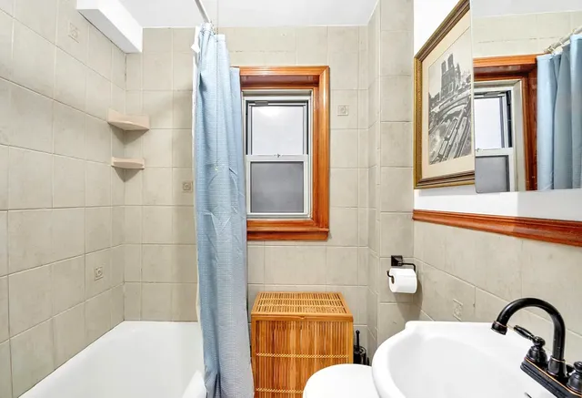 a bathroom with sink shower and mirror