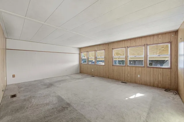 an empty room with a fireplace and windows