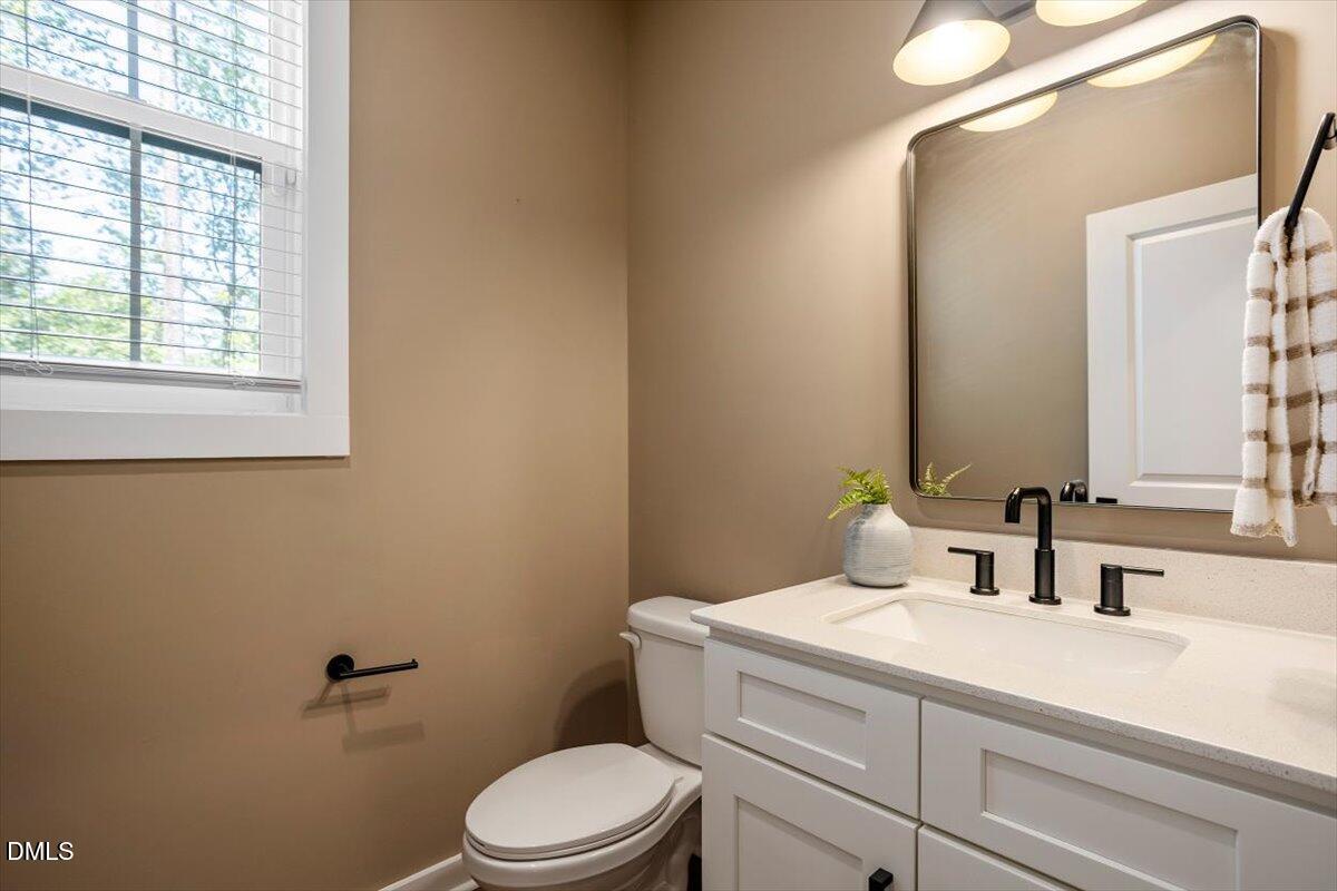 6419 Tanner Oak Lane Raleigh, NC 27613 - Photo 19 of 39 a bathroom with a granite countertop toilet sink and mirror